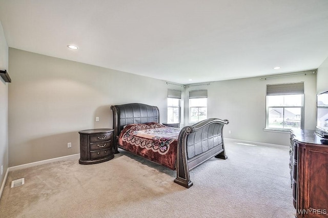 carpeted bedroom featuring recessed lighting, baseboards, visible vents, and multiple windows