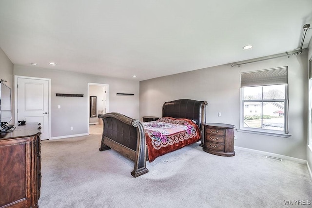 carpeted bedroom featuring baseboards, recessed lighting, ensuite bath, and visible vents