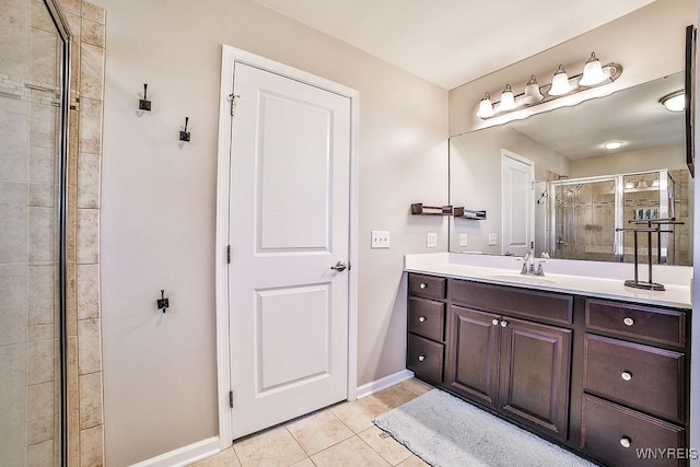 bathroom with baseboards, a shower stall, tile patterned flooring, and vanity
