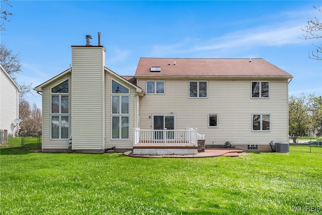 back of house with a chimney, fence, a wooden deck, cooling unit, and a lawn