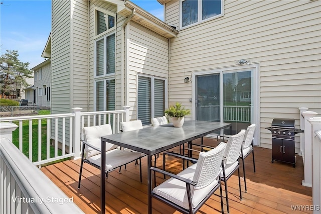 deck with outdoor dining space and area for grilling