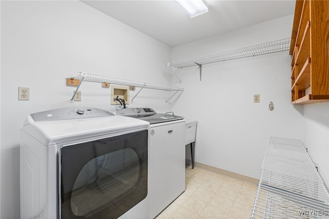 laundry room with separate washer and dryer, cabinet space, and light floors