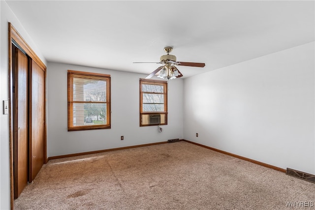 unfurnished bedroom featuring carpet flooring, a closet, cooling unit, visible vents, and baseboards