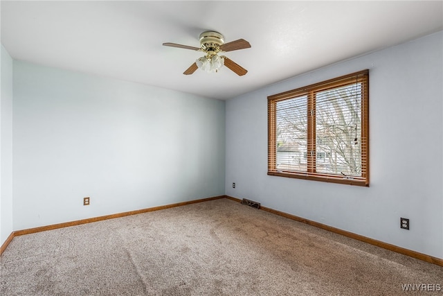 carpeted empty room with baseboards, visible vents, and ceiling fan