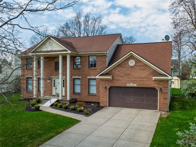 greek revival inspired property featuring a front lawn, driveway, an attached garage, and brick siding