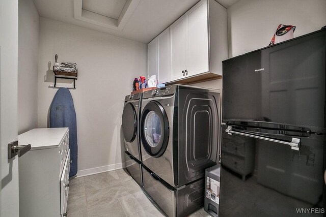 clothes washing area with attic access, baseboards, cabinet space, and washing machine and dryer
