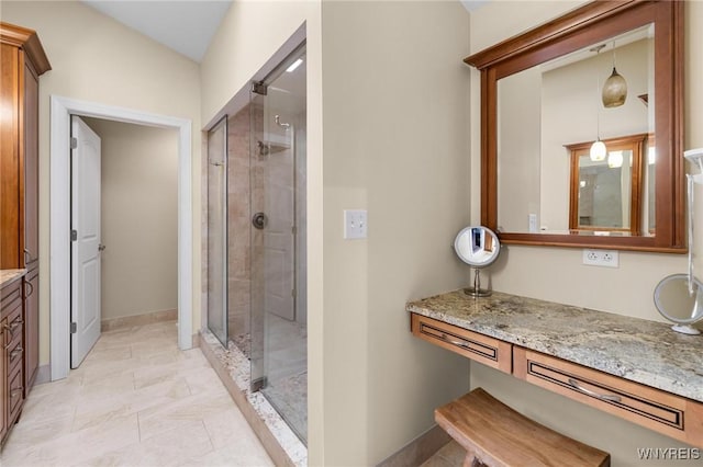 bathroom with vanity, a shower stall, and baseboards