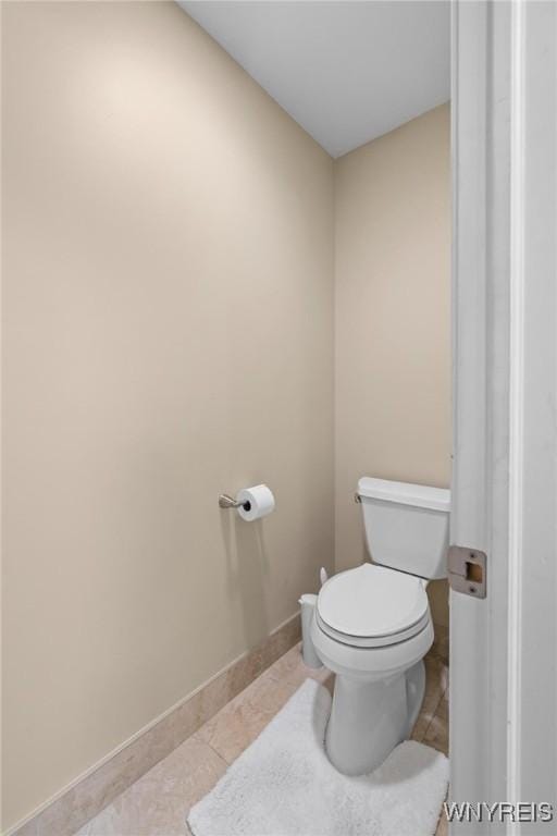 bathroom with tile patterned floors, baseboards, and toilet