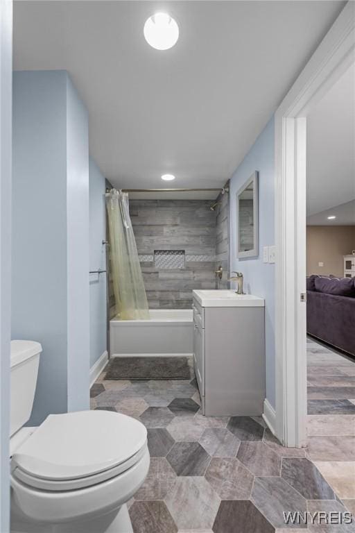 ensuite bathroom with recessed lighting, toilet, vanity, baseboards, and shower / tub combo