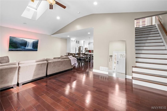 living room with wood finished floors, a skylight, stairs, visible vents, and a ceiling fan