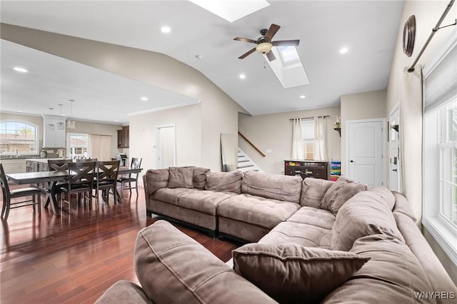 living room with vaulted ceiling with skylight, dark wood-style flooring, recessed lighting, a ceiling fan, and stairs
