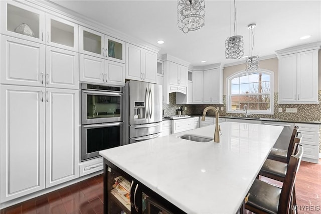 kitchen featuring dark wood finished floors, recessed lighting, appliances with stainless steel finishes, a sink, and white cabinetry
