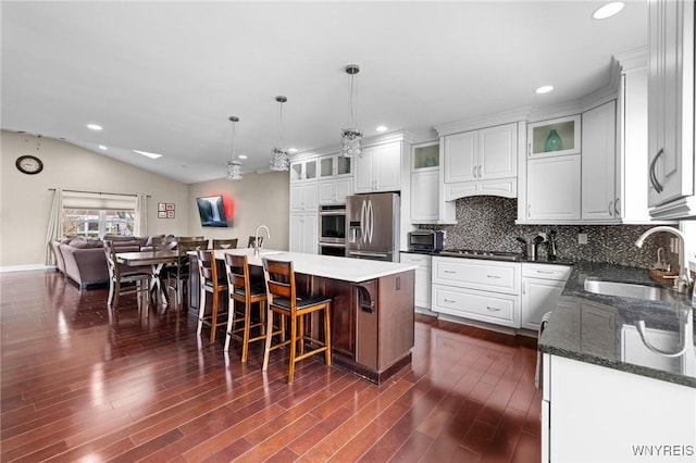 kitchen featuring recessed lighting, appliances with stainless steel finishes, backsplash, a sink, and lofted ceiling