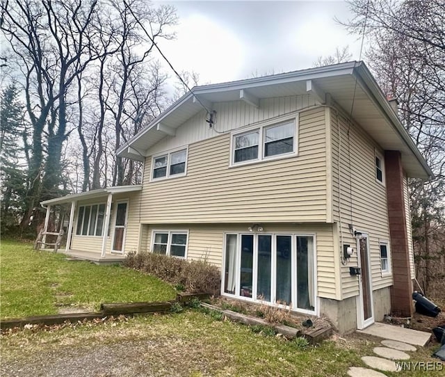 rear view of property with a yard