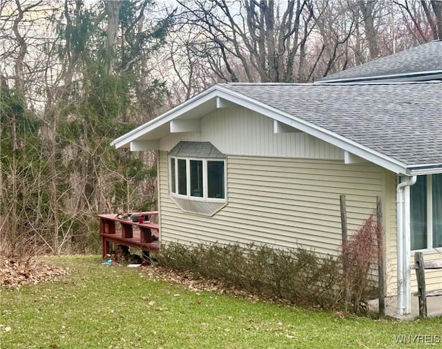 view of home's exterior featuring a lawn and roof with shingles