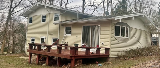rear view of property with a wooden deck and a carport