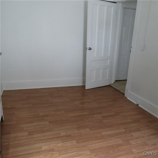 unfurnished room featuring light wood-style flooring and baseboards