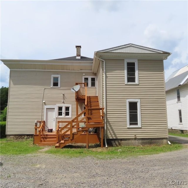 rear view of property with a deck and stairs