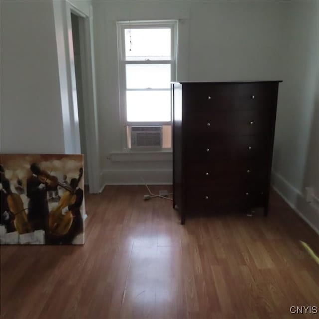 bedroom with cooling unit and light wood-style flooring