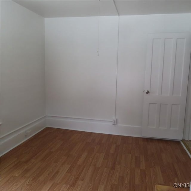 spare room featuring wood finished floors and baseboards