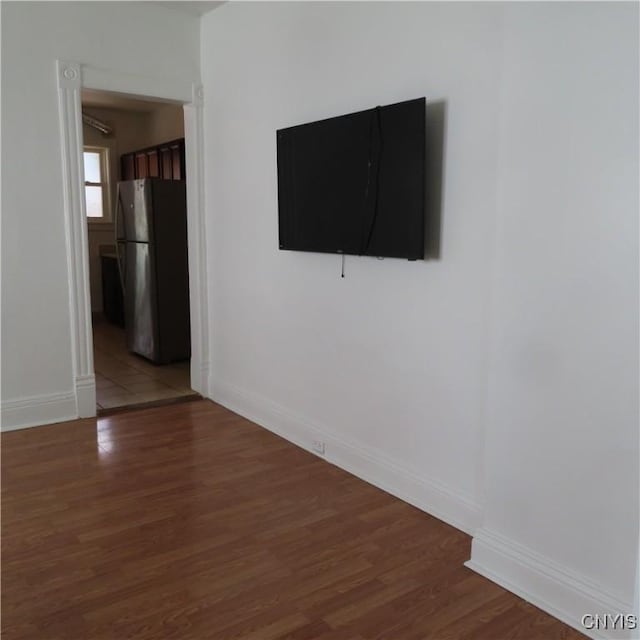 spare room featuring wood finished floors and baseboards
