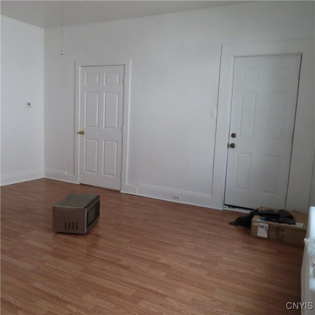 empty room with baseboards and light wood-style floors