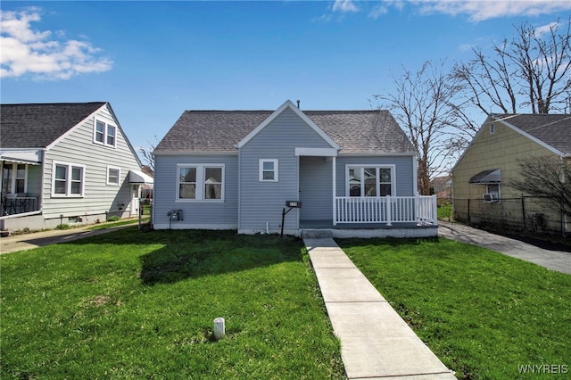 bungalow with fence, a porch, a front yard, and roof with shingles