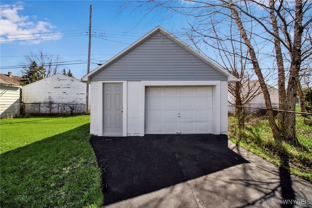 detached garage featuring fence and driveway