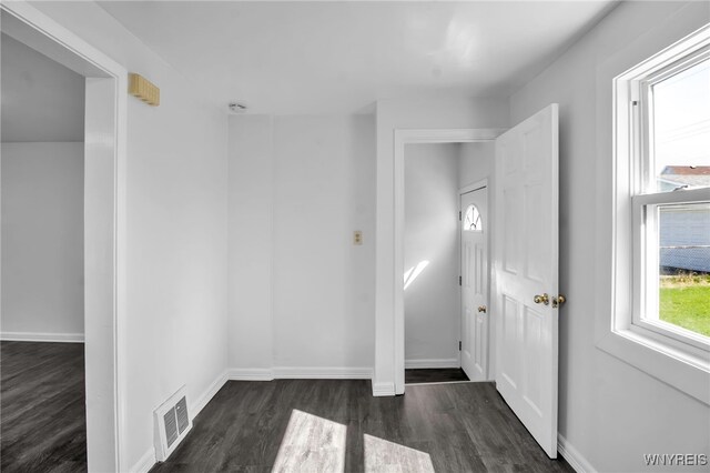 foyer featuring baseboards, visible vents, and dark wood-type flooring