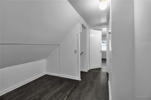 bonus room featuring vaulted ceiling, dark wood finished floors, and baseboards