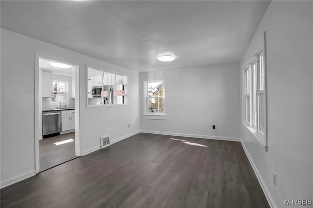 interior space featuring a sink, dark wood-style floors, visible vents, and baseboards