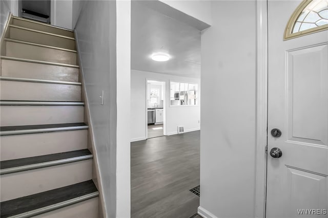 staircase featuring baseboards and wood finished floors