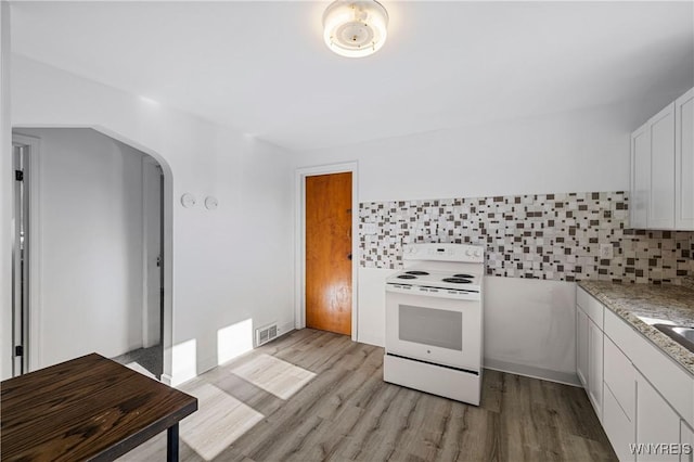 kitchen with visible vents, arched walkways, electric range, and light wood finished floors