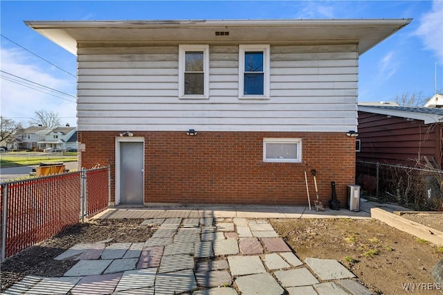 back of house with fence, a patio area, and brick siding