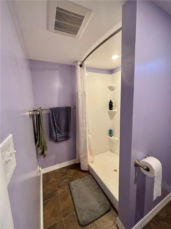 bathroom with tile patterned floors, visible vents, a shower stall, and baseboards