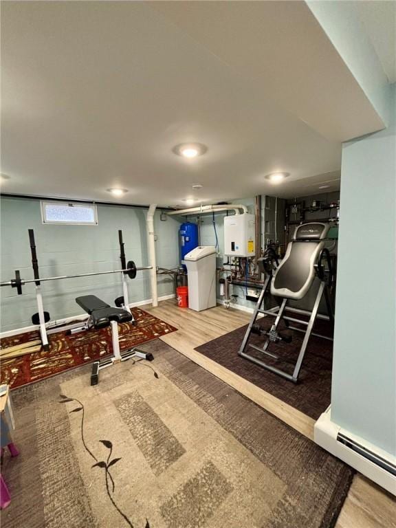 exercise area featuring wood finished floors and a baseboard radiator