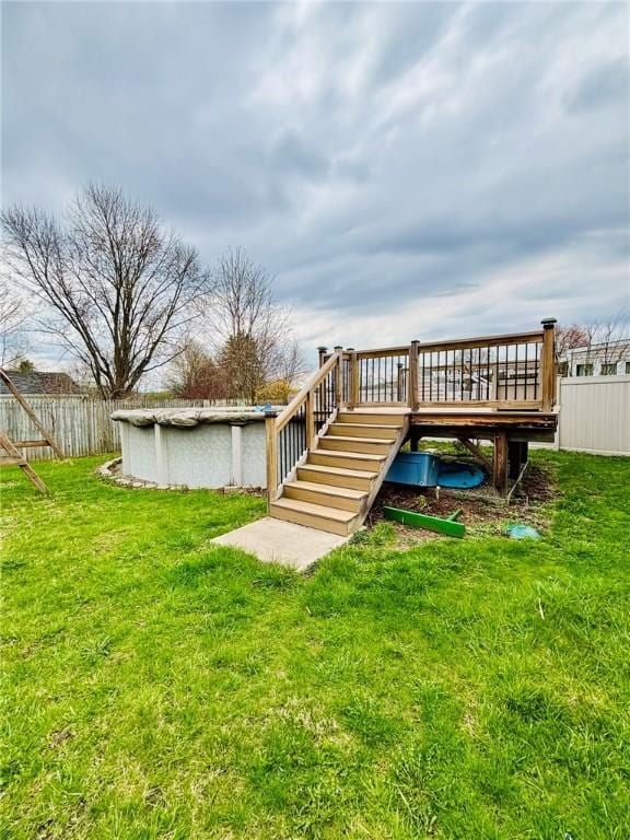 back of house featuring fence, stairway, a yard, and a covered pool