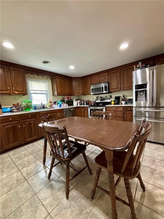 kitchen with recessed lighting, stainless steel appliances, light countertops, and light tile patterned floors