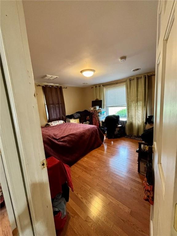 bedroom with visible vents and wood finished floors
