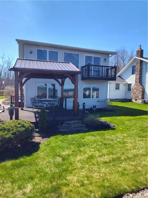 rear view of house featuring a patio, metal roof, and a lawn