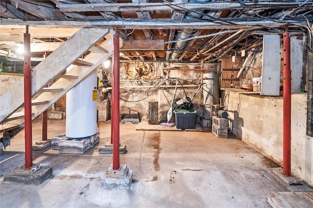 unfinished below grade area featuring stairway and water heater