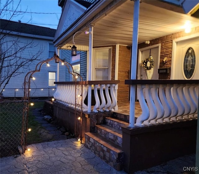 entrance to property featuring fence and a porch