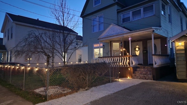 view of front of home with covered porch and a fenced front yard