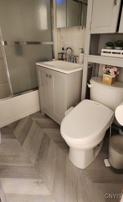 full bathroom featuring enclosed tub / shower combo, toilet, decorative backsplash, and vanity