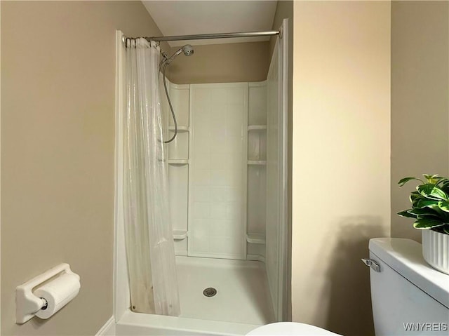 full bathroom with a shower stall and toilet