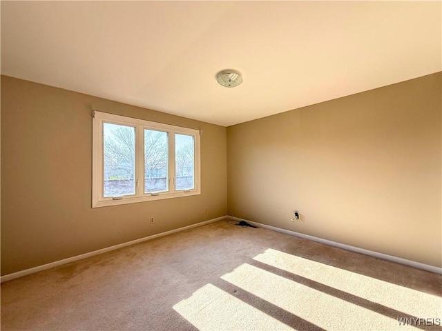 carpeted empty room with baseboards