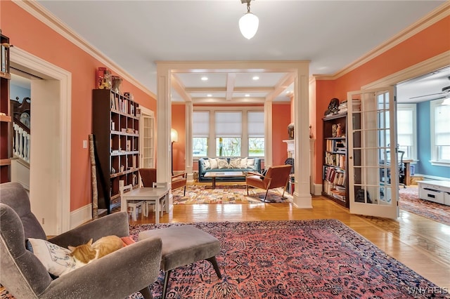 living area featuring baseboards, ornamental molding, wood finished floors, and french doors