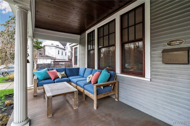 wooden terrace with an outdoor living space