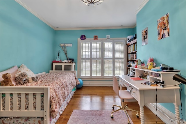 bedroom with crown molding and wood finished floors