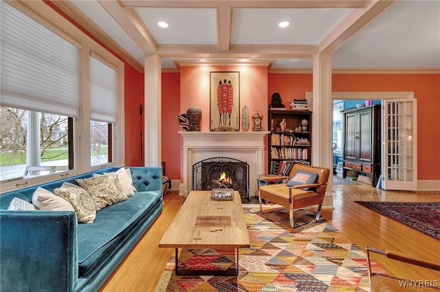 living area featuring wood finished floors, a warm lit fireplace, and crown molding
